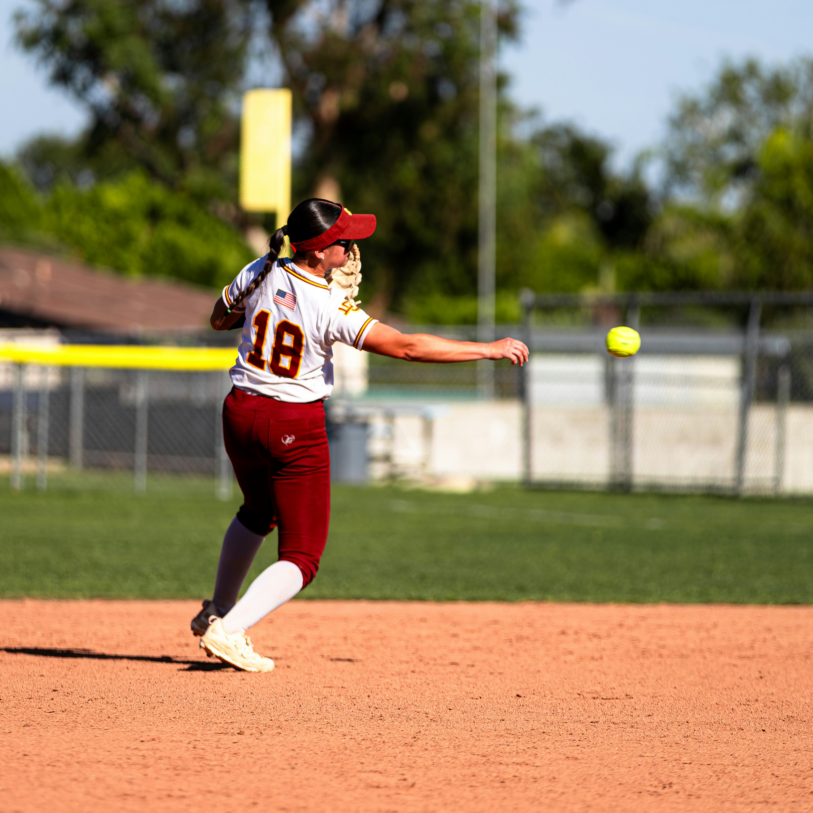 Softball player swinging bat